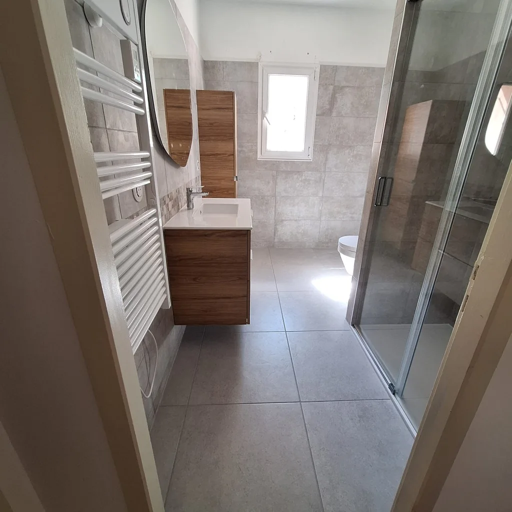 Rénovation salle de bain à Brignoles — Transformation baignoire en douche — gris & miroir rond, après travaux
